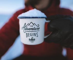 an explorer holding a motivational cup