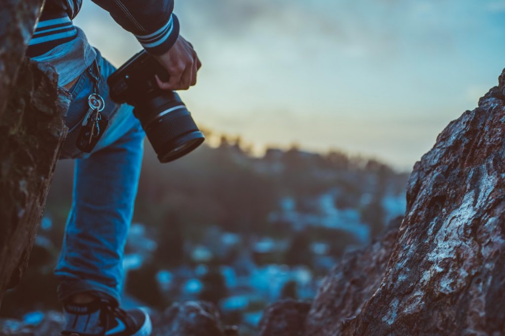 a person holding a camera outdoors